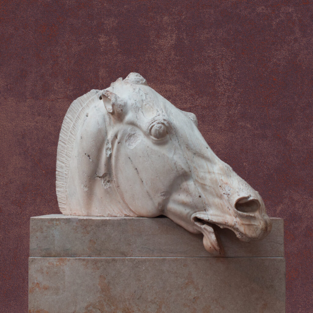 A statue of a horse head sits atop a stone pedestal in front of a pinkish purple concrete wall. The horse is exhausted, mouth ajar, nostrils flared.
